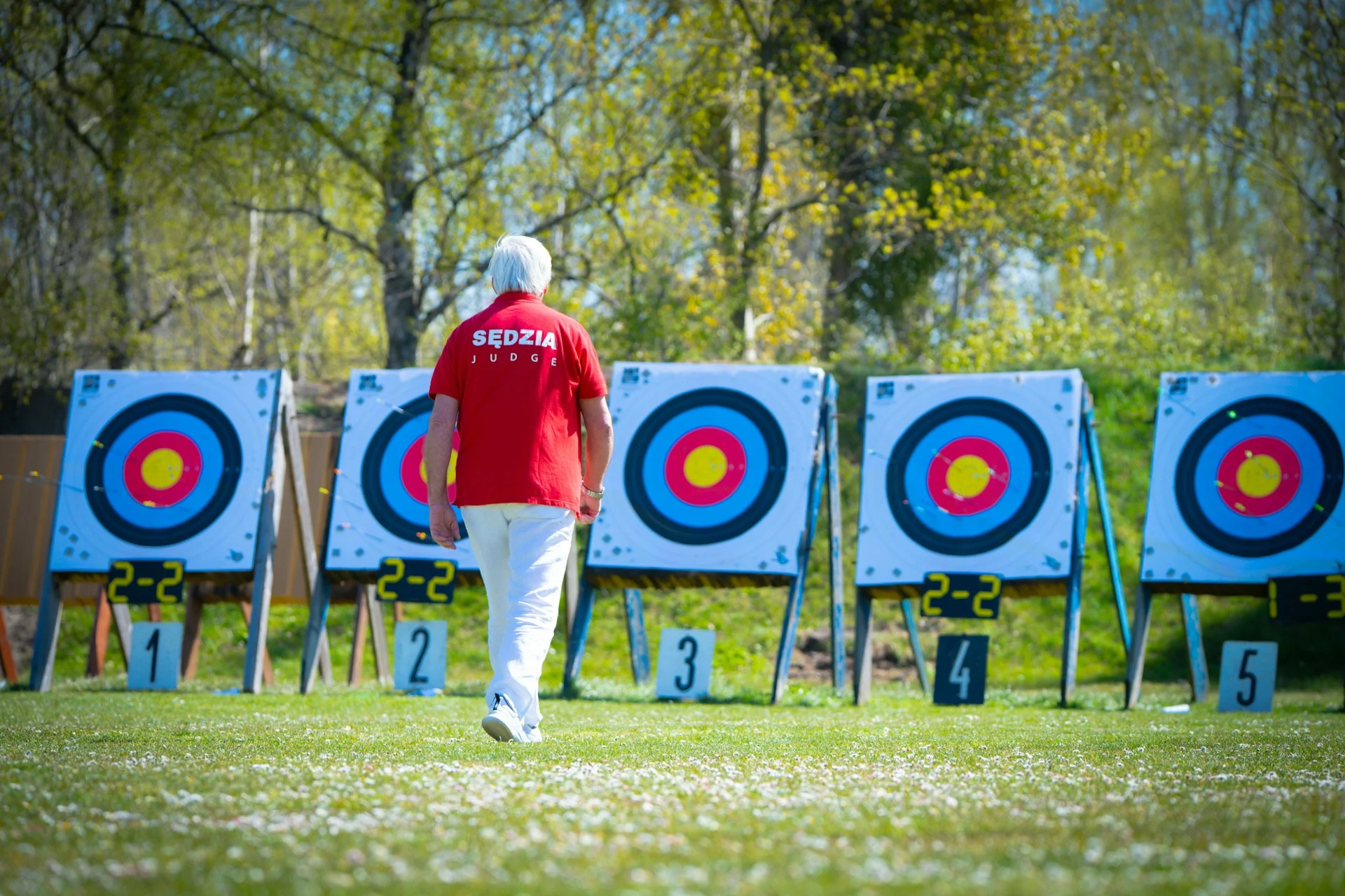 Archer walking toward a row of targets on an archery range